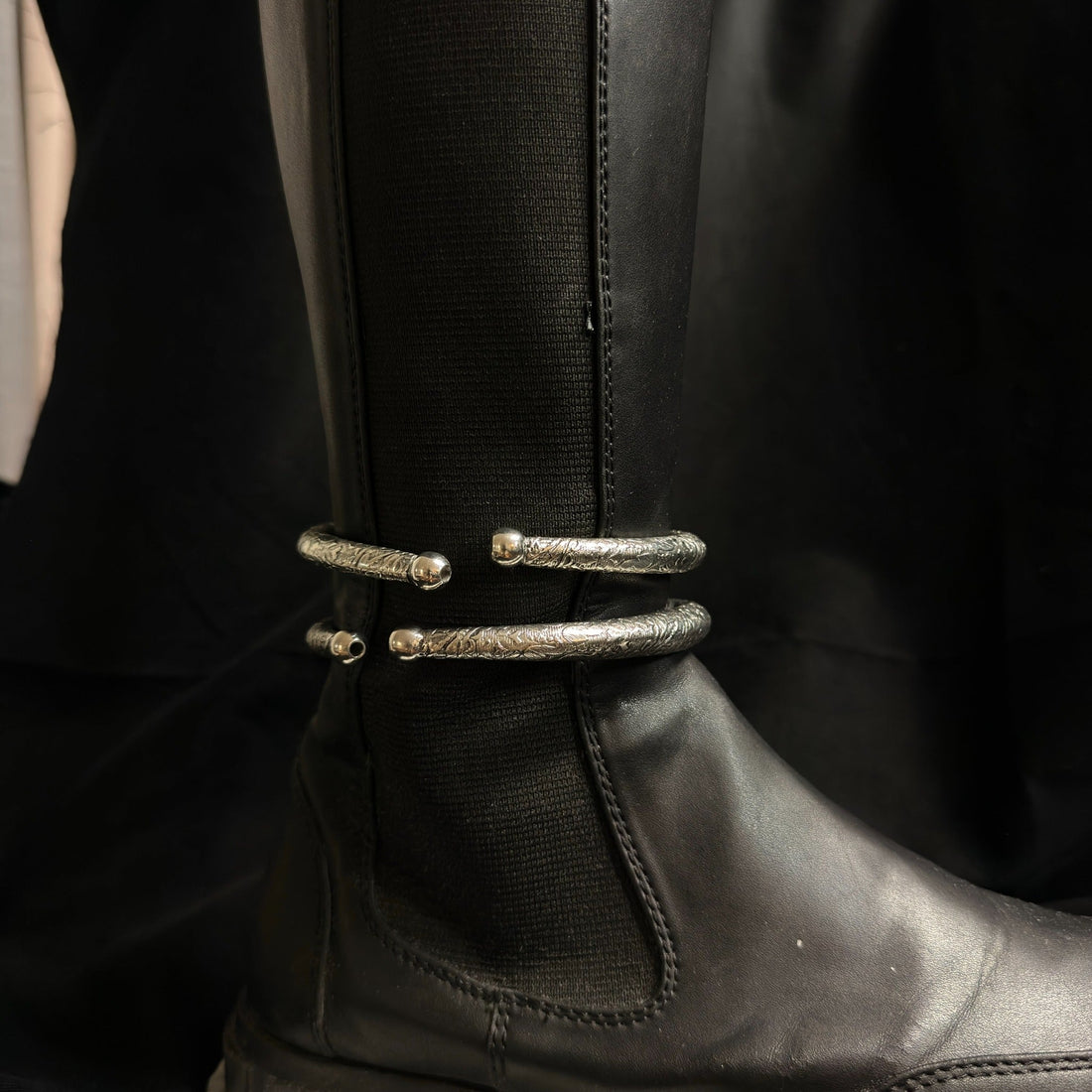 Engraved boot cuff jewelry detail on black boot