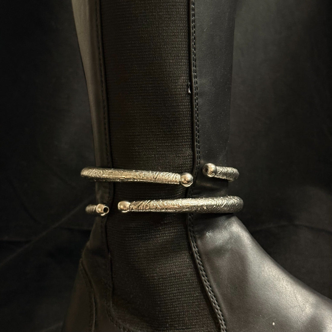 Stacked engraved boot cuffs on black boot