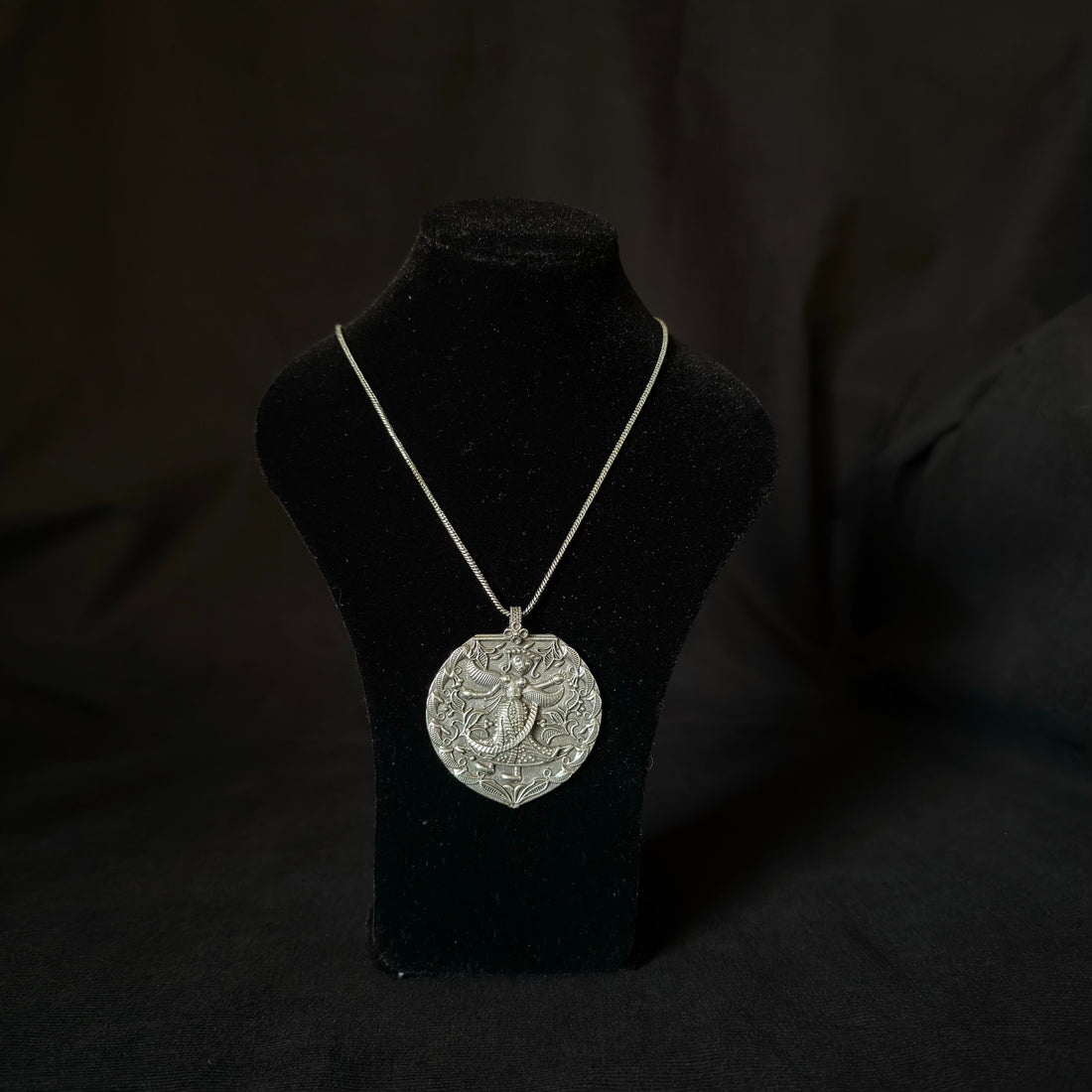 Oxidized brass figurative medallion necklace close-up