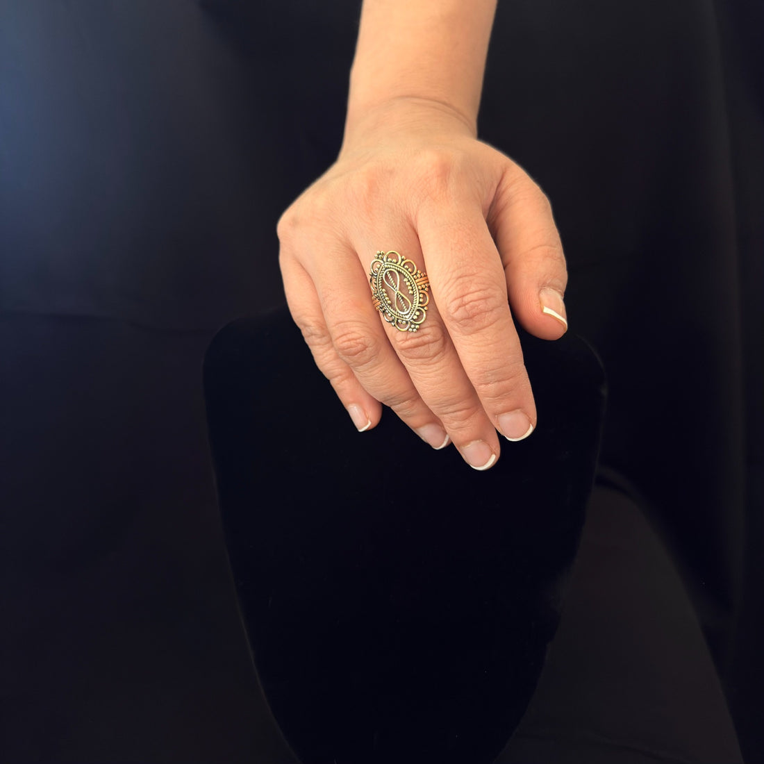 Ornate infinity ring worn on hand